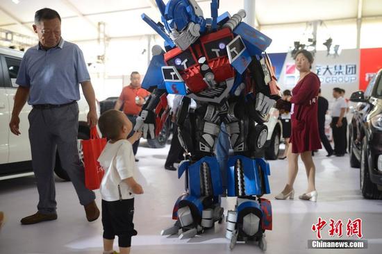 6月30日，車展上的“變形金剛”為主辦方造勢(shì)。當(dāng)日，2016第八屆呼和浩特國(guó)際汽車展覽會(huì)開幕，展會(huì)為期5天，國(guó)內(nèi)外近80個(gè)汽車品牌以及30多家汽配商企參展，同時(shí)還設(shè)有汽保、老爺車、金融、改裝以及汽車行業(yè)相關(guān)服務(wù)等展示區(qū)，參展車型近500余款。中新社記者
